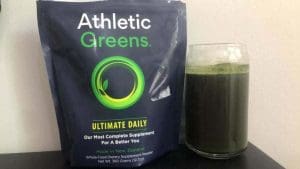 Athletic Greens drink next to the bag